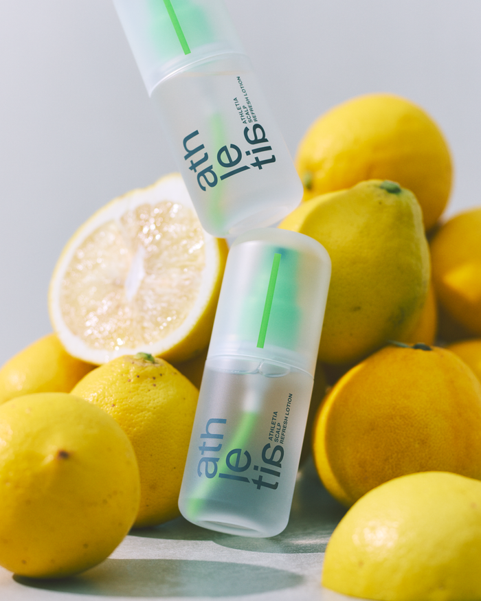 lemons in the background with a transparent athletia scalp refresh lotion