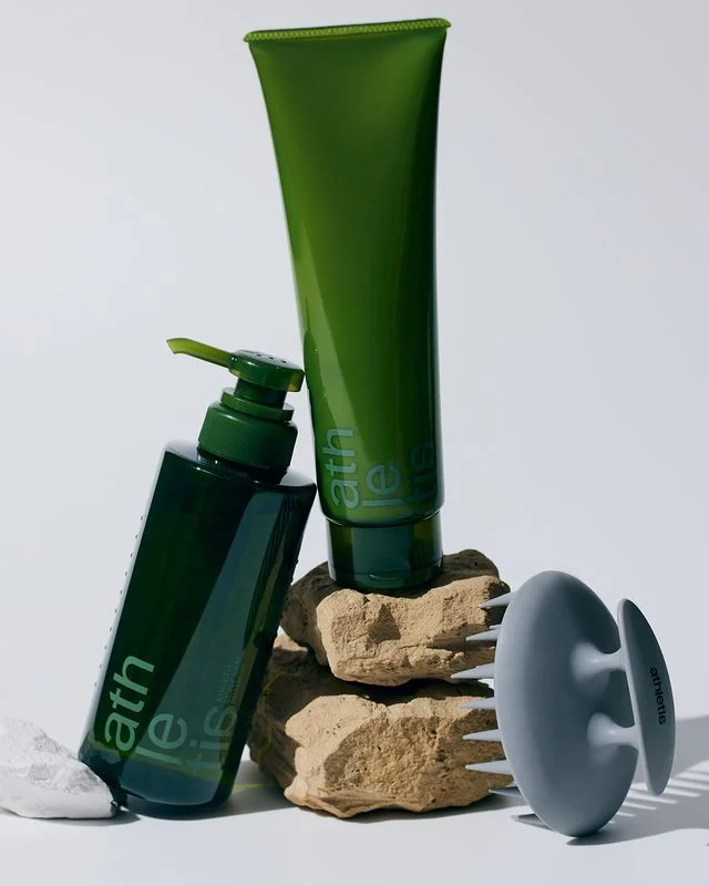 scalp care shampoo in a green bottle and hair treatment in a green bottle